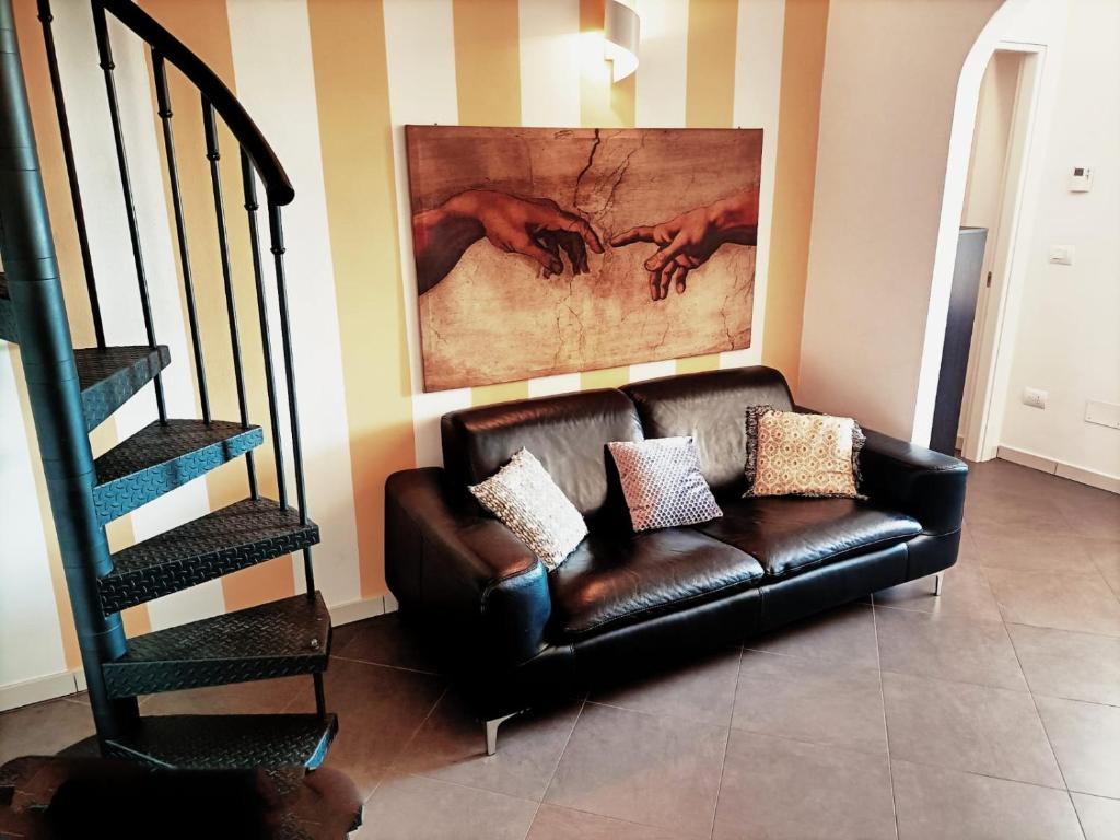 a leather couch in a living room with a painting at Lucky House Pisa in Cascina