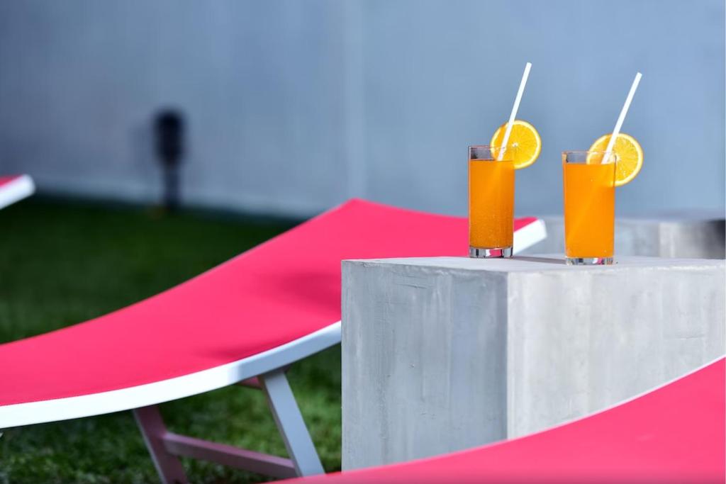 una mesa con dos cócteles naranjas en ella con una silla en Thushine Hotel en Seeduwa