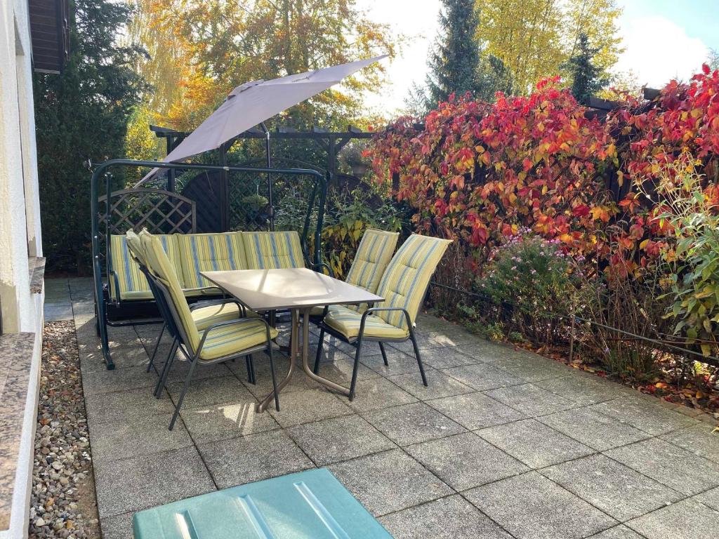 a table and chairs with an umbrella on a patio at Ferienwohnung Waldsiedlung in Mühl Rosin