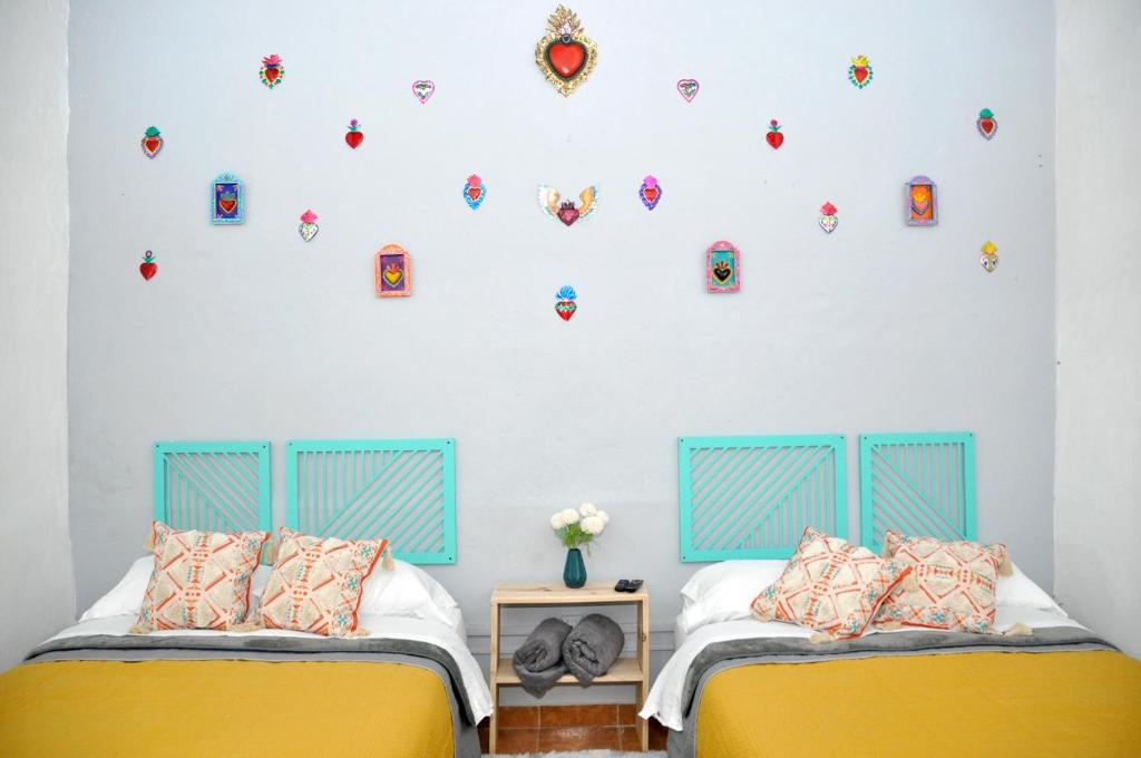 2 camas en un dormitorio con una pared con pegatinas en REFORMA 62 en Querétaro