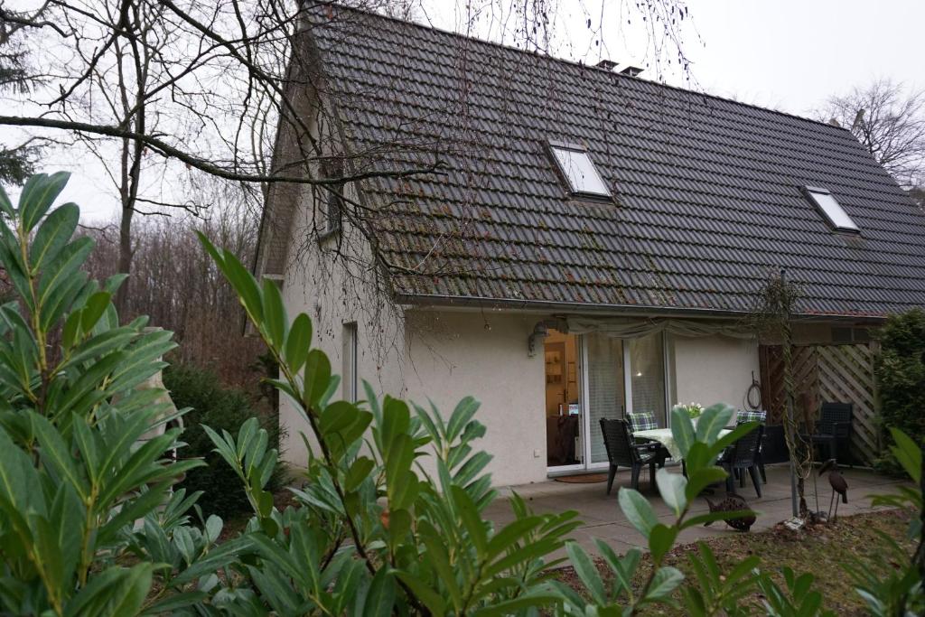 una pequeña casa blanca con techo negro en Residenz am Ziest, en Lalendorf