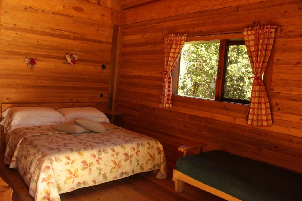 a bedroom with a bed in a log cabin at La quiete di Ileana Sofian in Pamparato