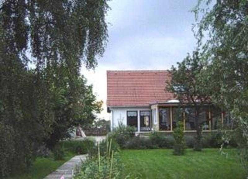 una casa con techo rojo en un patio en Ferienhof Augustenruh, 