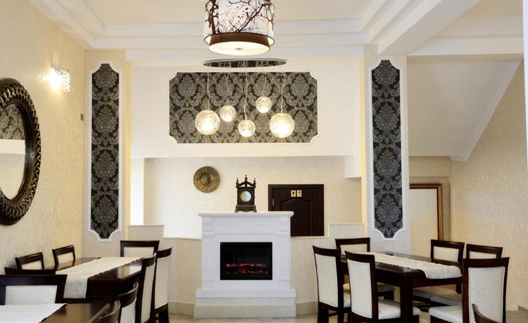 a dining room with tables and chairs and a fireplace at Pensiunea Junior in Cluj-Napoca