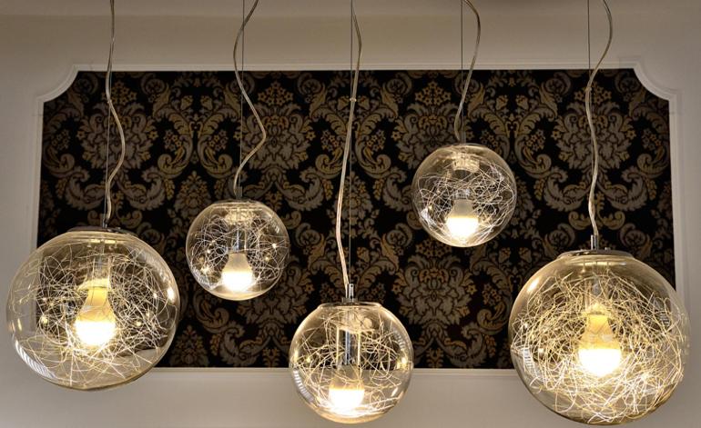 a group of glass lights hanging from a wall at Pensiunea Junior in Cluj-Napoca