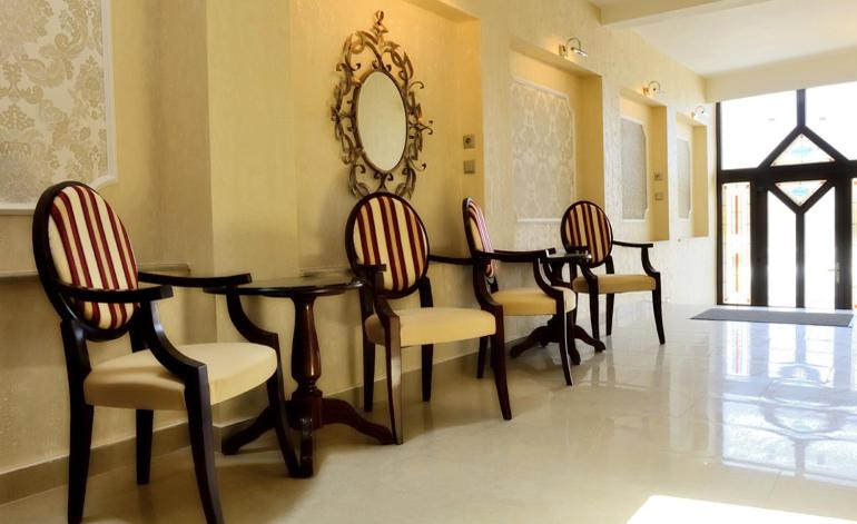 a dining room with a table and chairs and a mirror at Pensiunea Junior in Cluj-Napoca