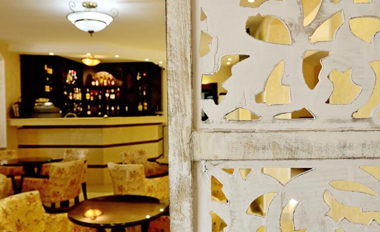 a restaurant with tables and chairs and a bar at Pensiunea Junior in Cluj-Napoca
