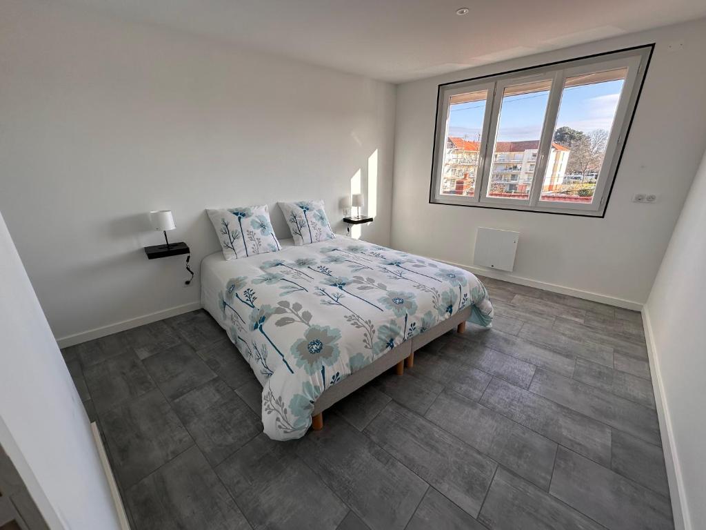 une chambre blanche avec un lit et une fenêtre dans l'établissement Envies D’Ailleurs Centre Ville, à Saint-Brévin-les-Pins