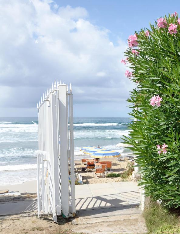 a white gate on the beach near the ocean at Beachside House in Sperlonga