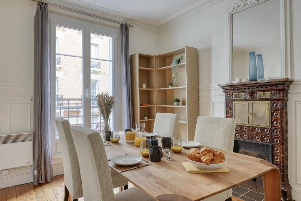 uma sala de jantar com uma mesa de madeira e cadeiras em Lovely & authentic Flat - Parc des Expos - Paris 15 em Paris