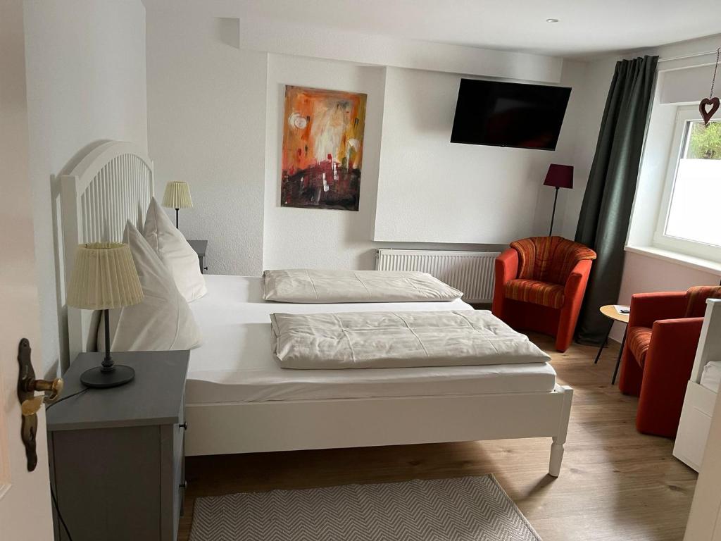 ein Hotelzimmer mit 2 Betten und einem TV in der Unterkunft Ferienwohung Auszeit am Eifelsteig in Gemünden
