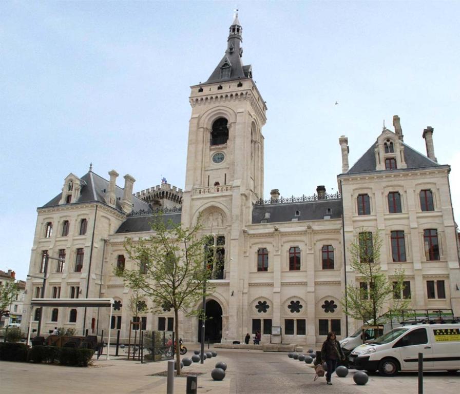ein großes Gebäude mit einem Uhrturm darüber in der Unterkunft La Suite Angoulême in Angoulême