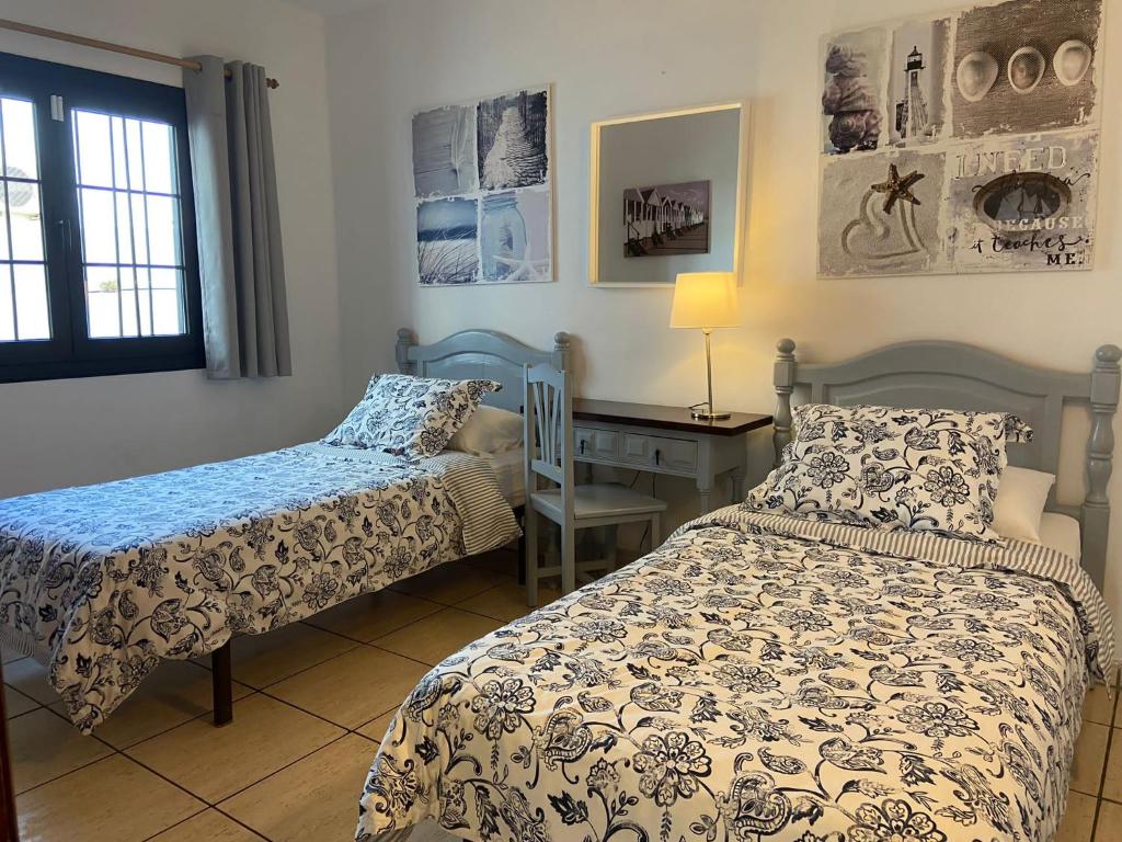 um quarto com 2 camas e uma secretária em Palm Villa em Puerto del Carmen