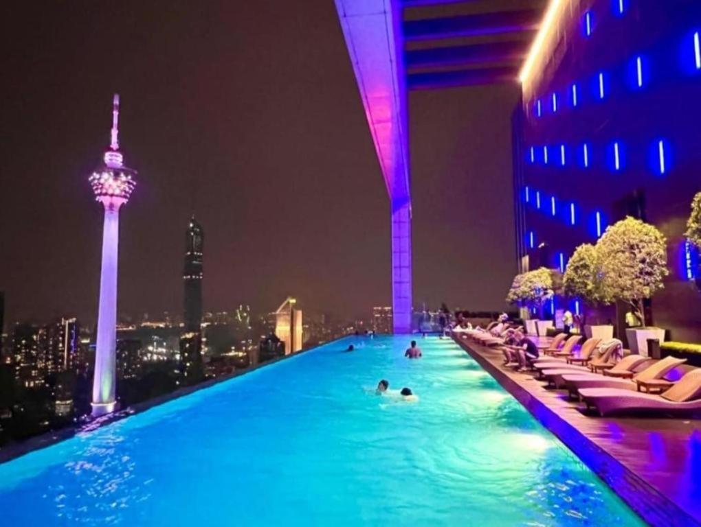 - une piscine au sommet d'un bâtiment la nuit dans l'établissement The platinum KLCC By Garden Suites, à Kuala Lumpur