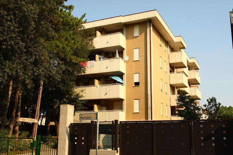 ein großes Apartmenthaus mit Menschen auf einem Balkon in der Unterkunft CONDOMINIO PINO VERDE in Bibione