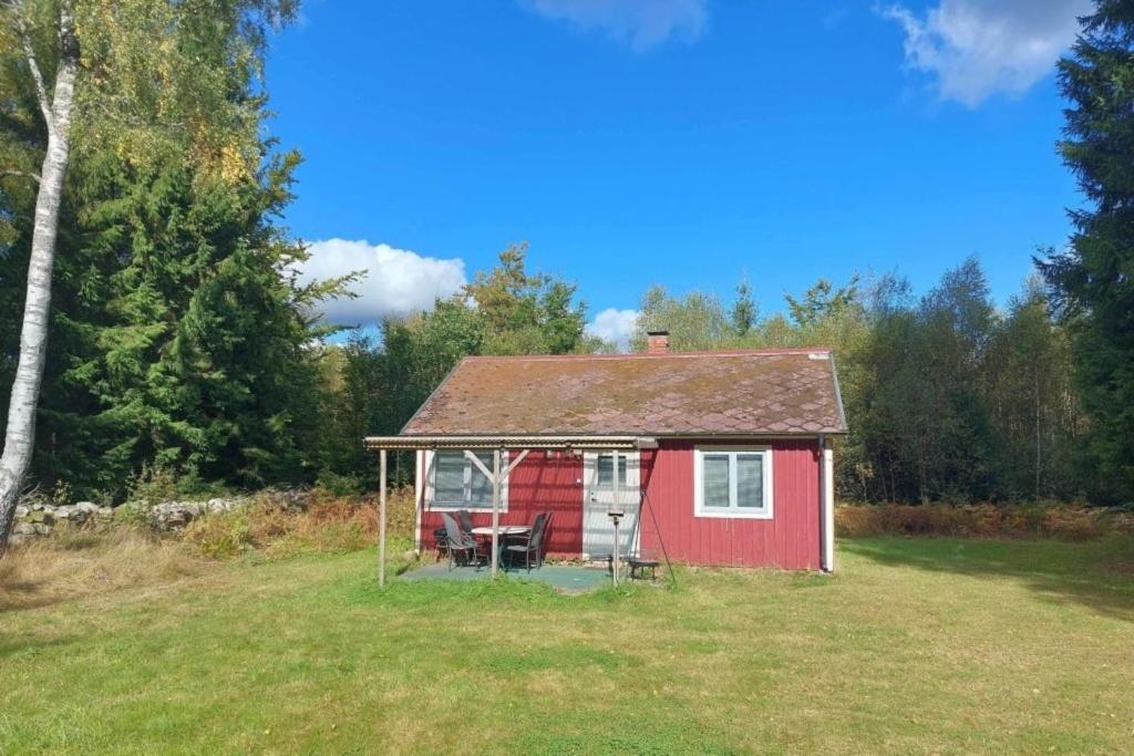 ein kleines rotes Haus mitten auf einem Feld in der Unterkunft Woody in Brösarp