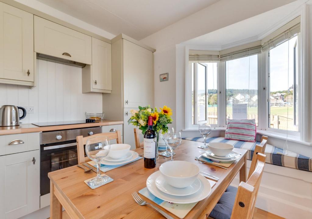 uma cozinha com uma mesa com pratos e flores em Marnies View em Sidmouth