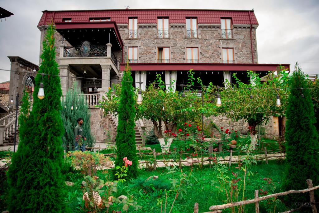 un gran edificio con un jardín delante de él en Khoreayi Dzor, en Goris