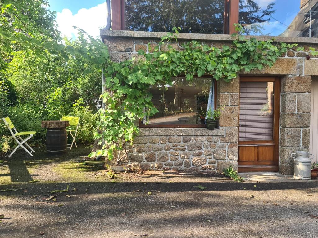 una casa de ladrillo con una ventana y una puerta en Chambre à la ferme, les vergers du Muscardin en Bréel