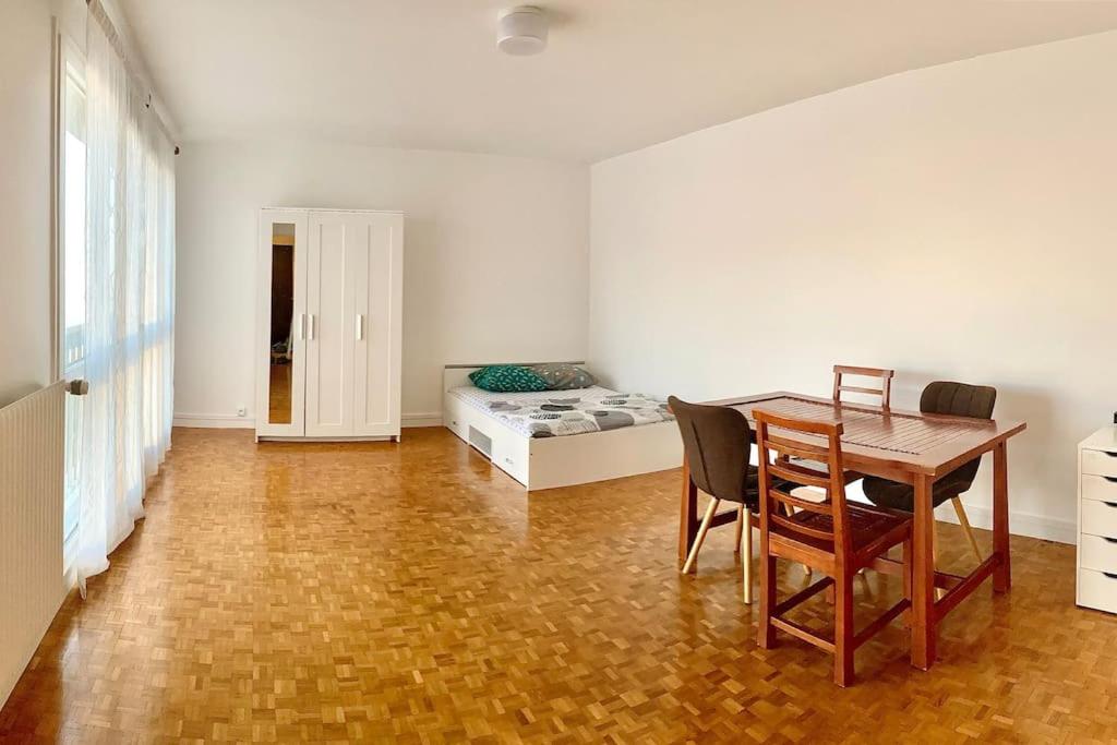 um quarto com uma mesa e cadeiras e uma cama em Appartement bien situé em Noisy-le-Grand