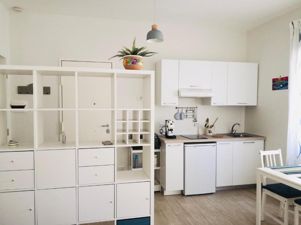 a white kitchen with white cabinets and a table at Appartamento "Sabu Home" Napoli Vomero Alto in Naples