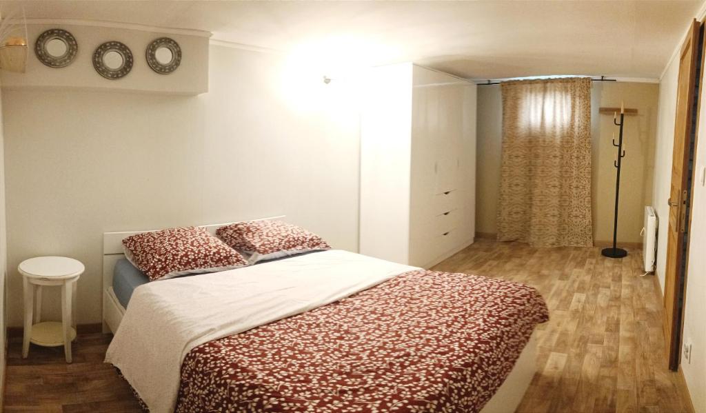 sypialnia z łóżkiem z czerwoną i białą pościelą w obiekcie Paisible appartement proche des 24h et du lac w mieście Arnage