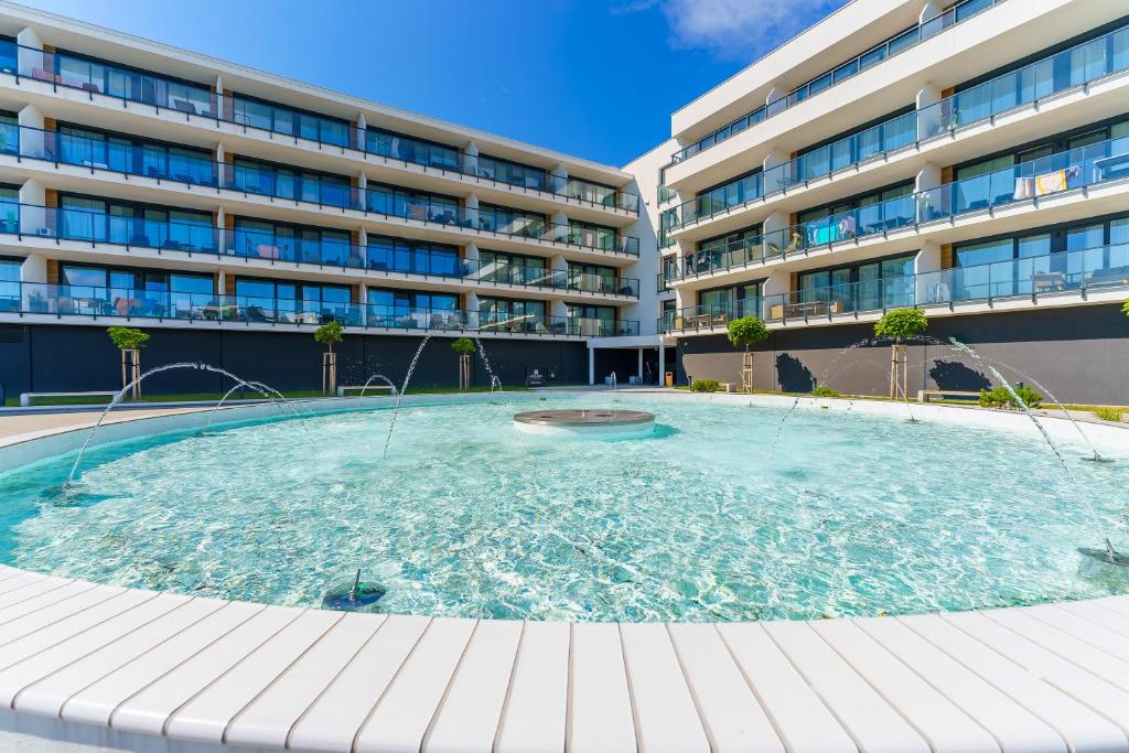 a large swimming pool in front of a building at Apartamenty Lighthouse - Westin House Resort in Kołobrzeg