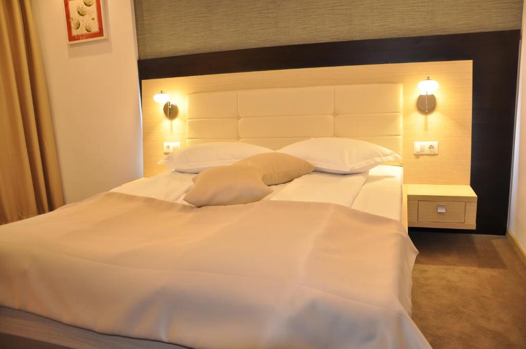 Hotel Nova في تارغوفيست: سرير ابيض كبير عليه وسادتين