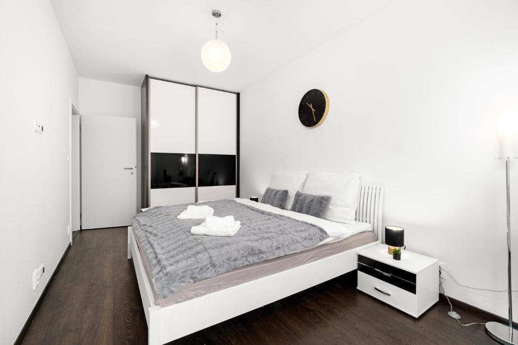 1 dormitorio blanco con 1 cama grande y espejo en BNB New Beautiful Apartment in the Center of Ostrava with option Garage Parking, en Moravská Ostrava