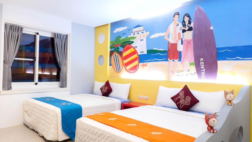 two beds in a room with surfboards on the wall at Ocean Star B&B in Kenting