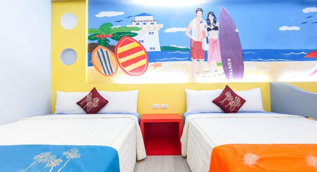 two beds in a room with surfboards on the wall at Ocean Star B&amp;B in Kenting