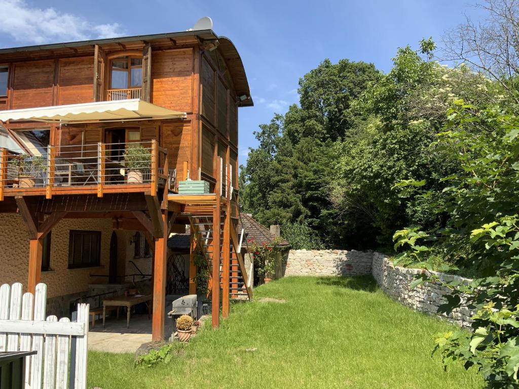 a wooden house with a deck and a yard at Living the Green in Friedrichsdorf
