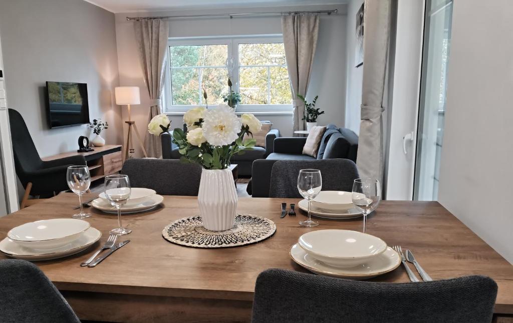 a dining room table with a vase of flowers on it at APARTMÁN POHODA in Svatava