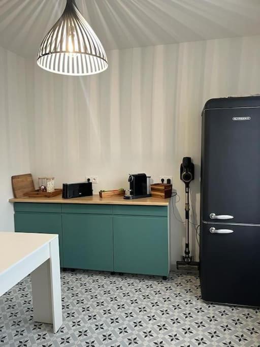 - une cuisine avec un comptoir bleu et un réfrigérateur noir dans l&#39;établissement appartement cosy 6 pers, à Noisy-le-Sec
