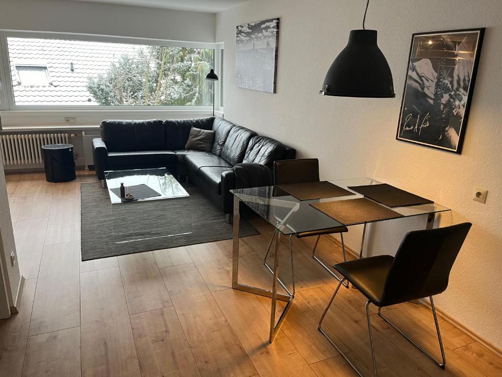 - un salon avec un canapé et une table en verre dans l'établissement 2 Zimmer Apartment - Wohnen auf Zeit, à Tübingen