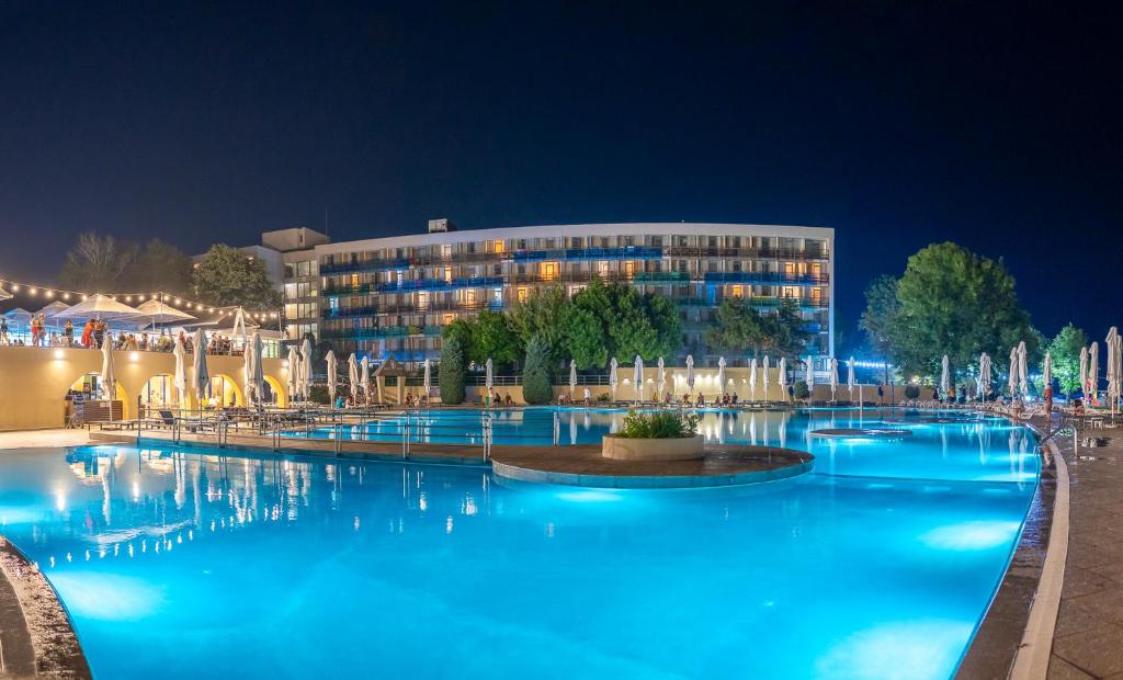 a hotel with a large swimming pool at night at Safir Blue Resort in Saturn