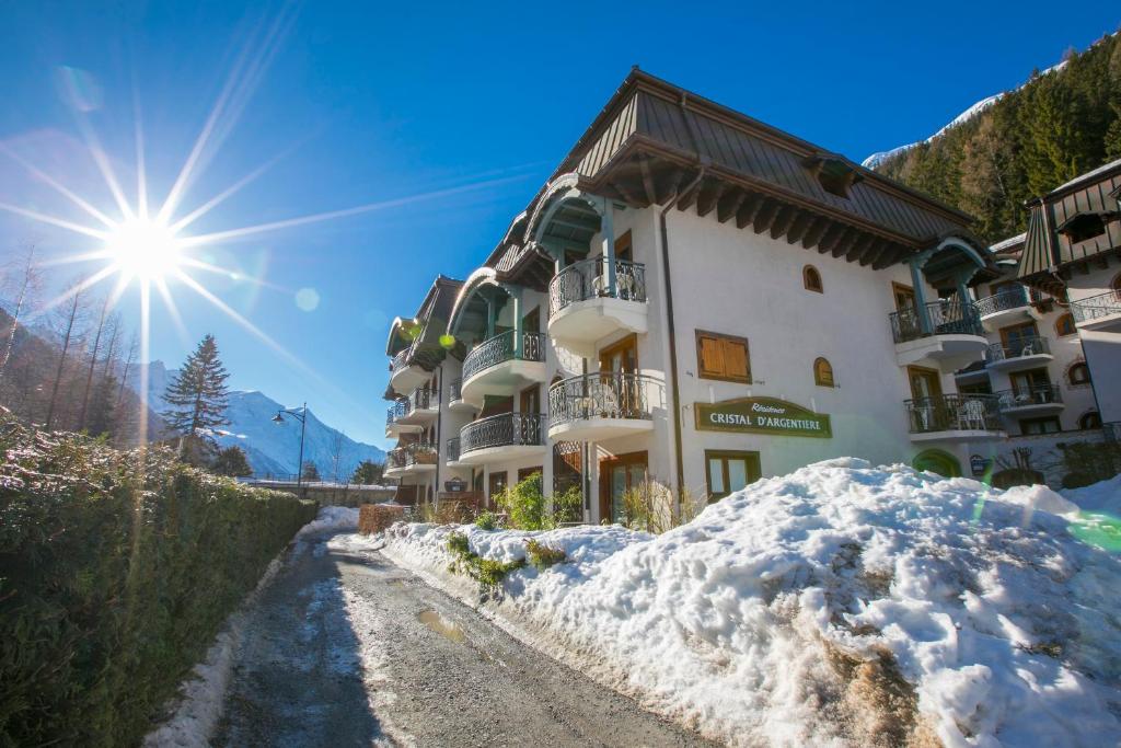 eine schneebedeckte Straße vor einem Gebäude in der Unterkunft Résidence Le Cristal Apartments - Happy Rentals in Chamonix-Mont-Blanc
