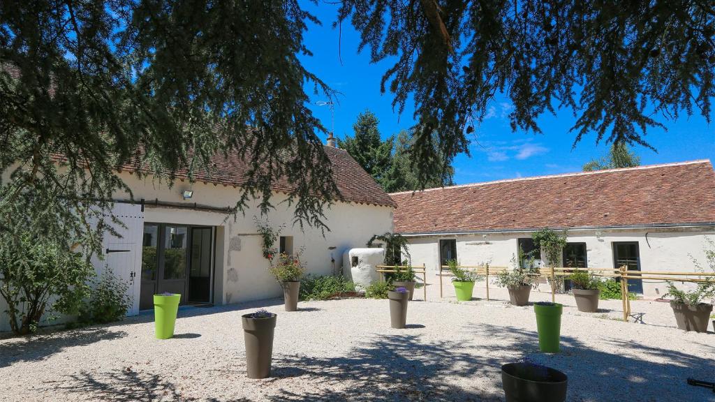 un bâtiment avec des plantes en pot devant dans l'établissement Le Verger de Pauline, à Maslives