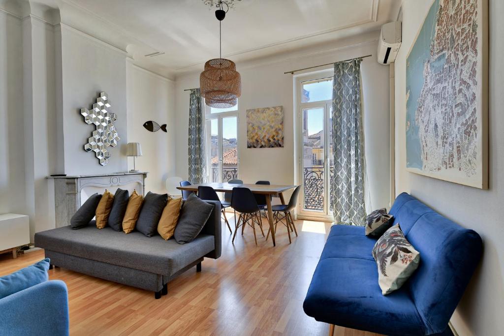a living room with a blue couch and a table at NOCNOC - Le Minot in Marseille