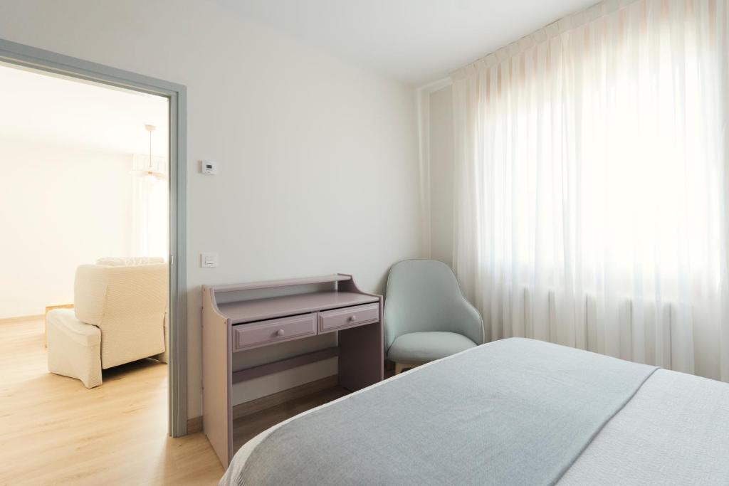 Schlafzimmer mit einem Bett, einem Schreibtisch und einem Stuhl in der Unterkunft Casa Cauma Apartamento in Albarracín