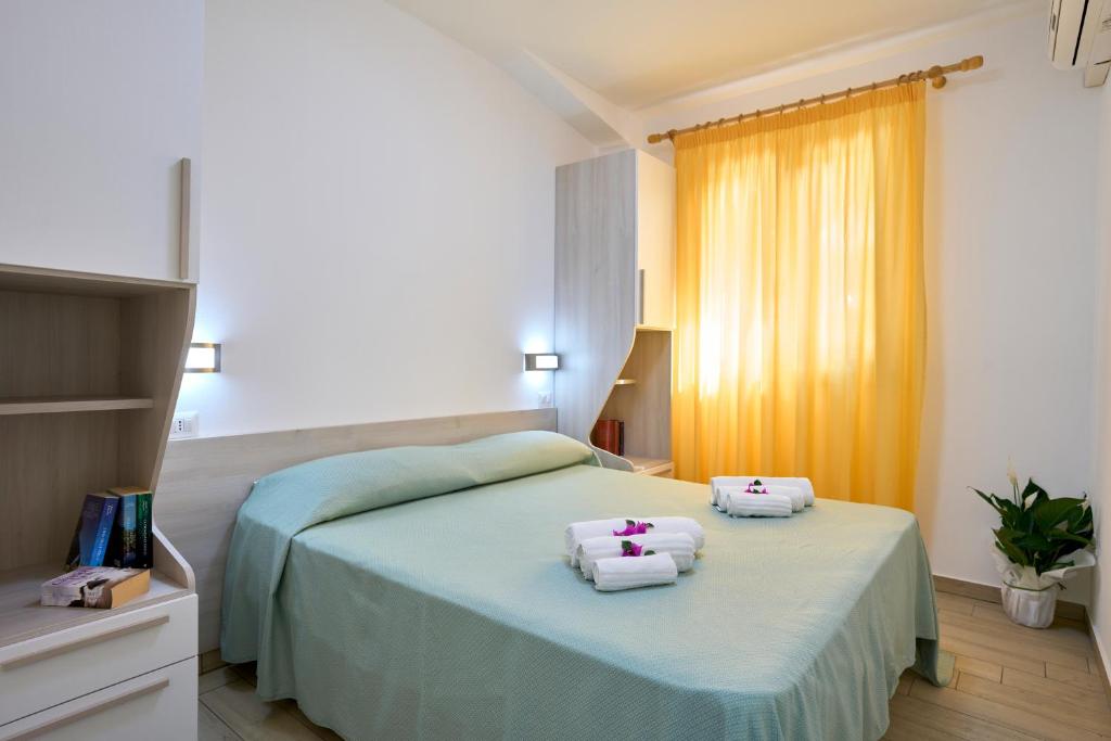 een slaapkamer met een bed met handdoeken erop bij Villaggio Santa Maria in Capo Vaticano