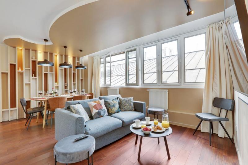 sala de estar con sofá azul y mesa en 220 Suite Jessy - Superb Apartment in Paris, en París