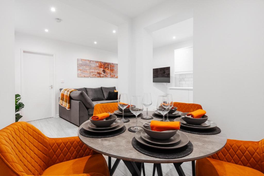 uma sala de jantar com uma mesa e cadeiras laranja em Brighton Apt - 2 Bedroom Free Wi-Fi & Parking em Wallasey