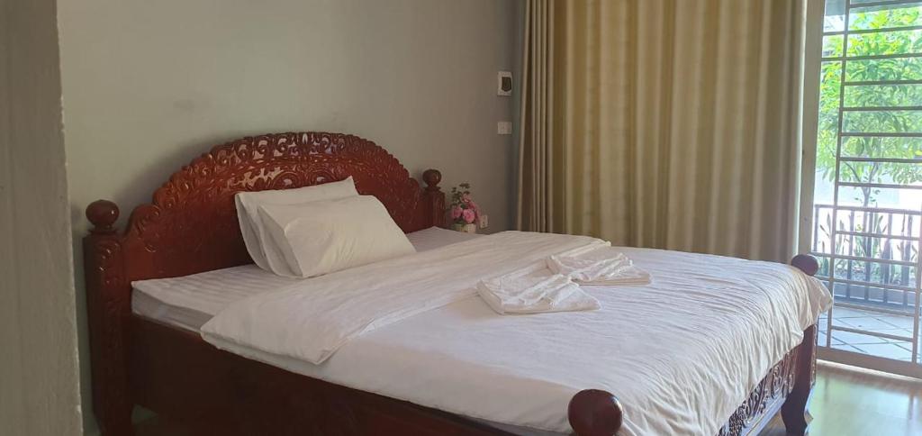 a bedroom with a bed with two towels on it at Angkearsel GuestHouse in Kampot