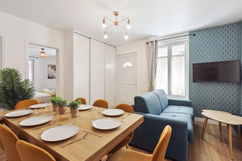 a dining room with a table and a blue chair at 864 Suite Iris - Superb apartment in Montreuil