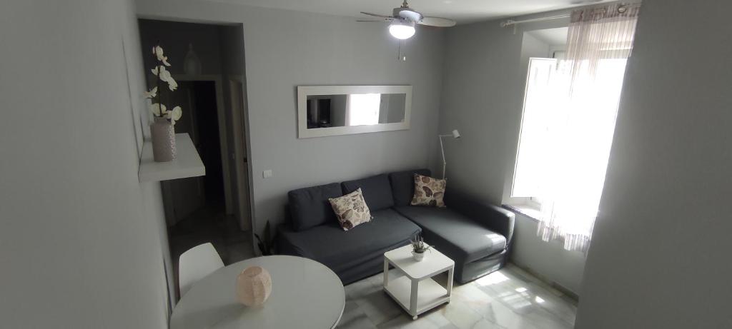 マラガにあるLovely Apartment in Pedregalejoのリビングルーム(青いソファ、テレビ付)