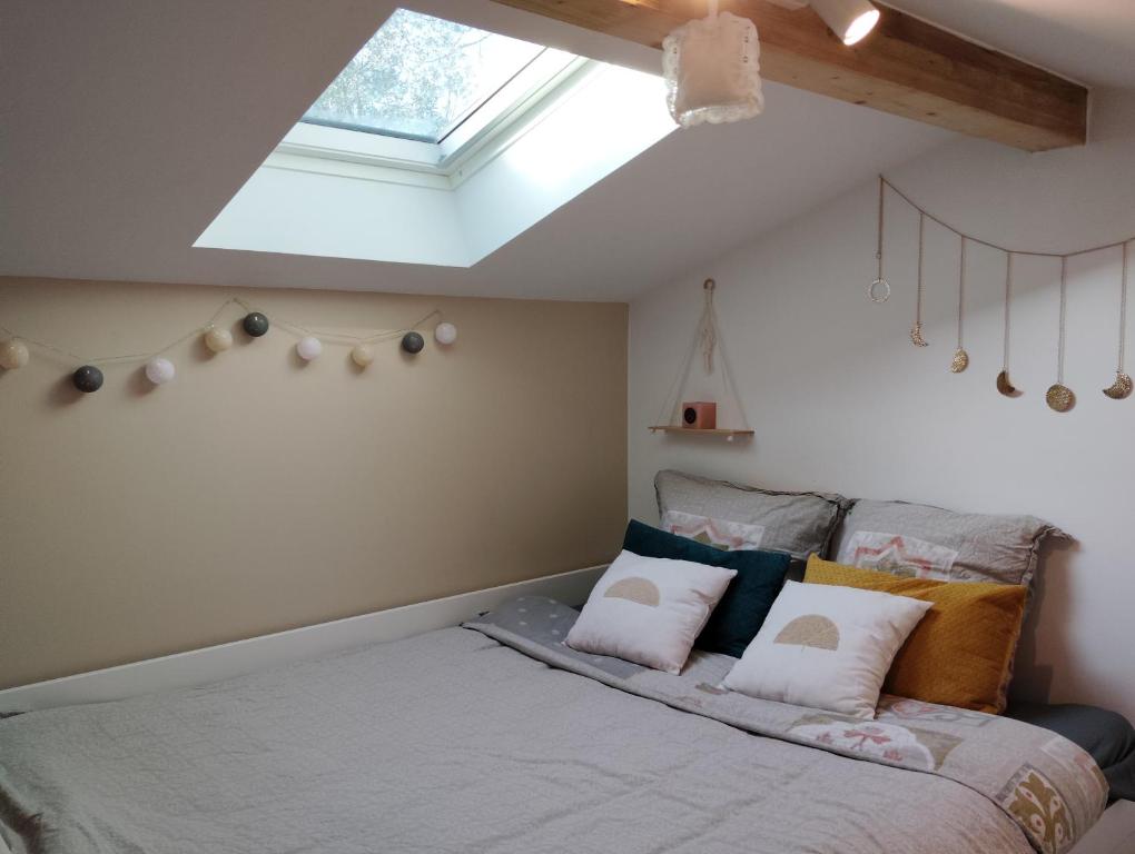 a bedroom with a bed with a skylight at Lodge 2 étoiles la tête dans les pins les pieds dans l eau in Lacanau