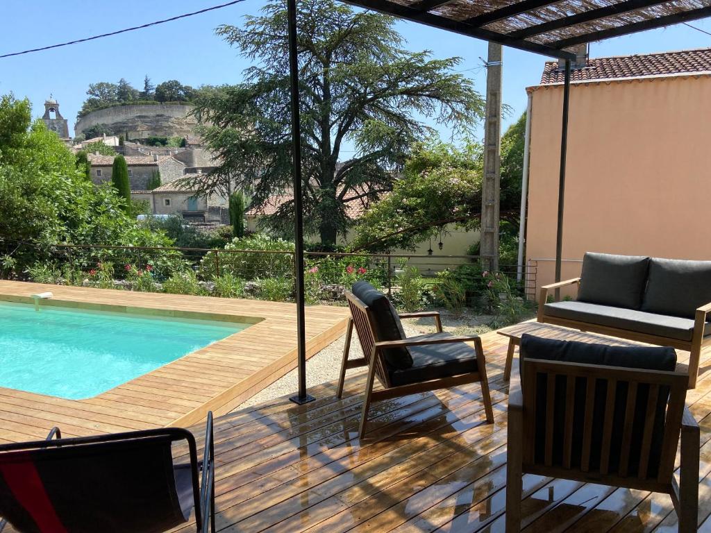 une terrasse avec des chaises et une piscine dans l'établissement LA MAISON DU PETIT JEU GRIGNAN, à Grignan