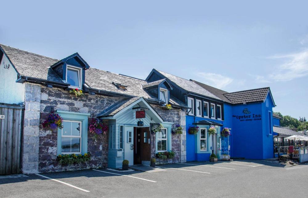 a row of blue buildings in a parking lot at Oyster Inn Connel in Oban