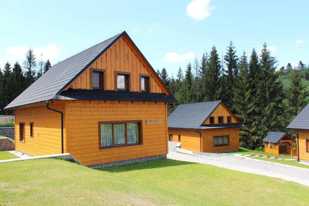 ein großes Holzhaus mit schwarzem Dach in der Unterkunft Chaty Hldočín, Uhliská, Ostražica, Zmrazov in Nižná